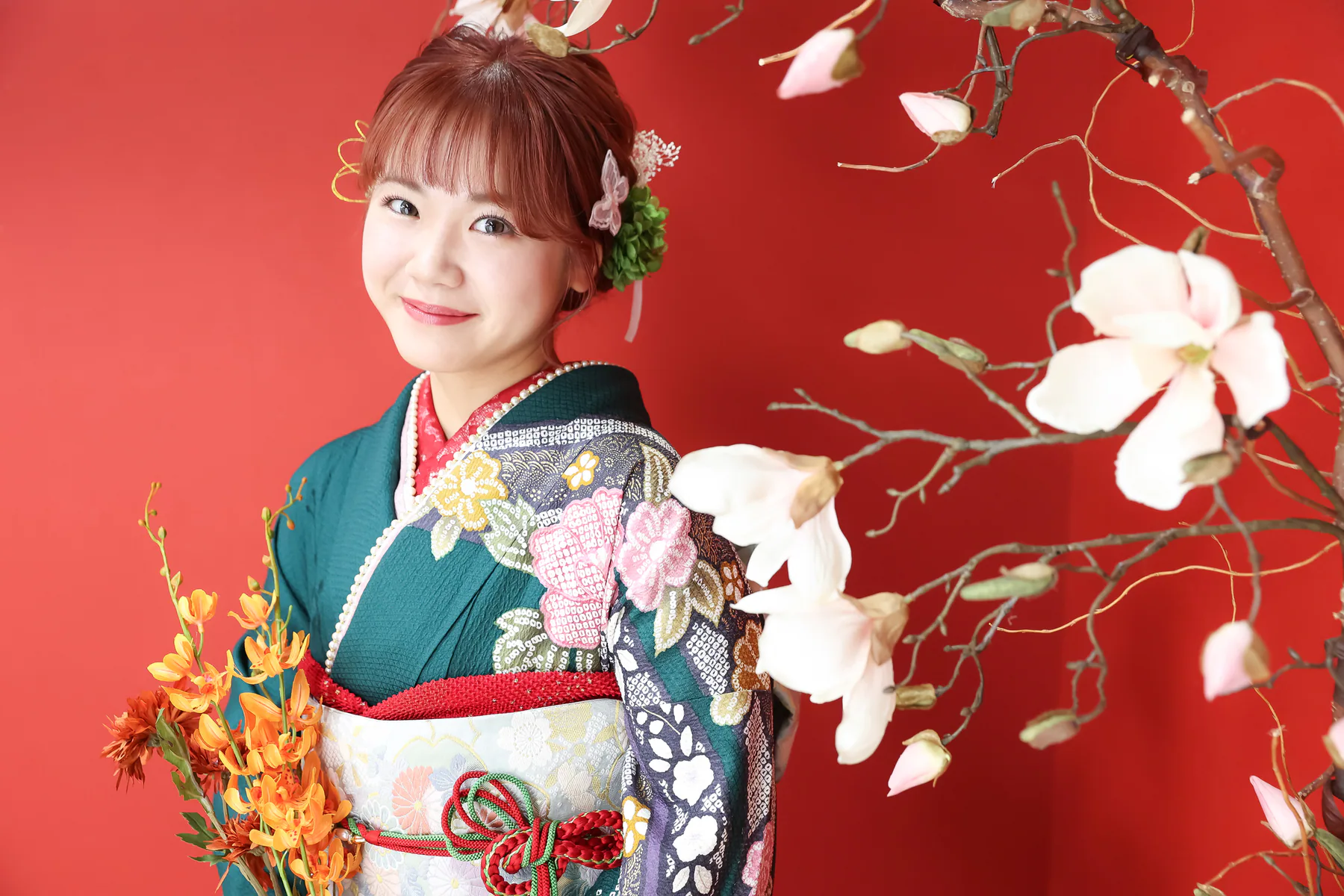 赤い背景で緑の振袖ポートレート